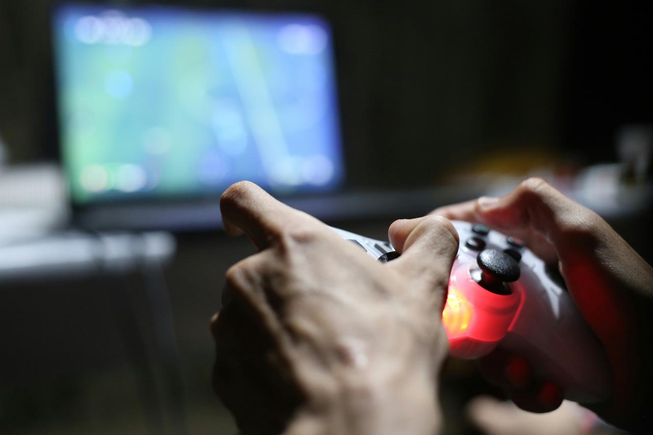person holding red and black plastic bottle