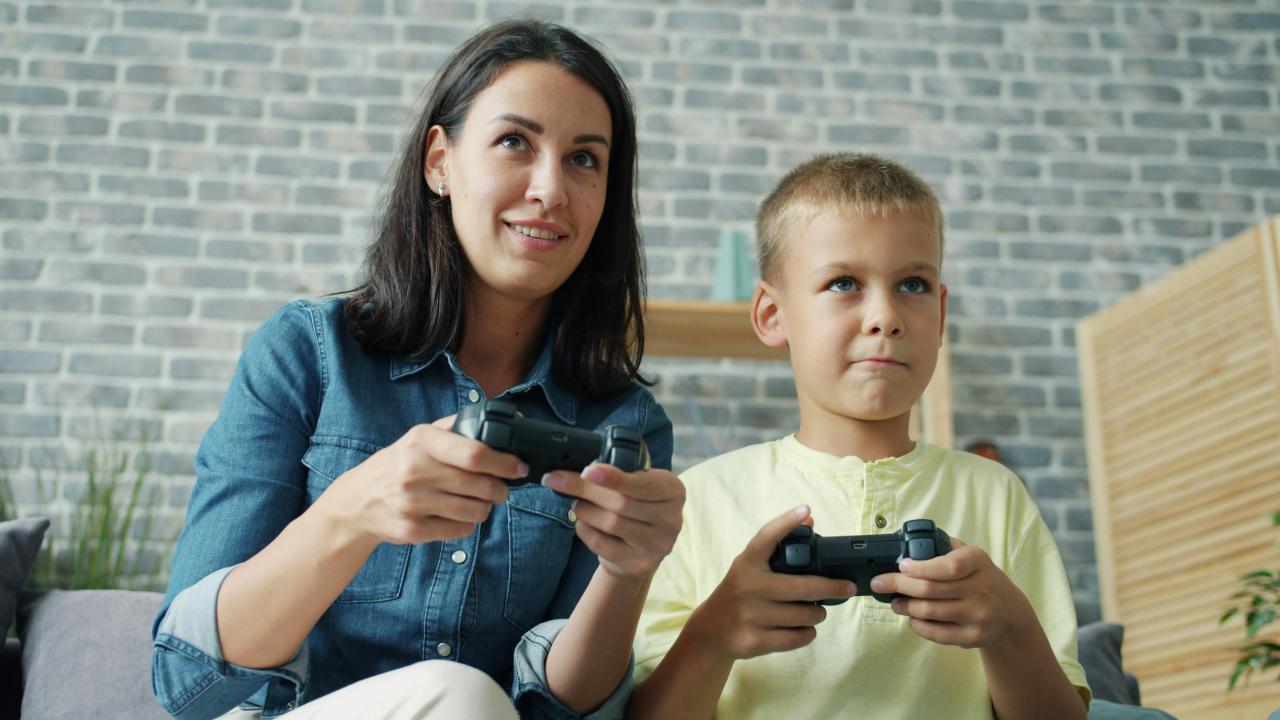 Mother and son playing video games together