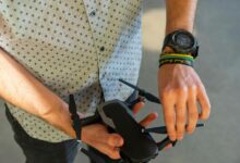 person holding black quadcopter drone