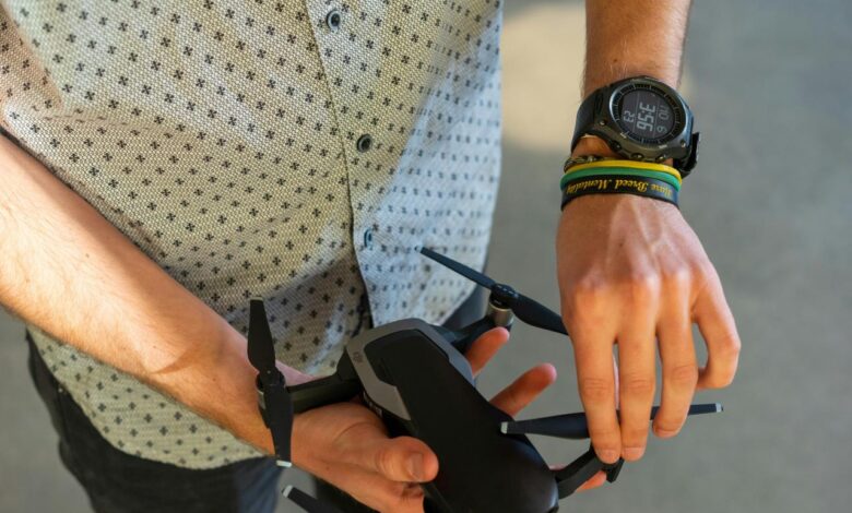 person holding black quadcopter drone