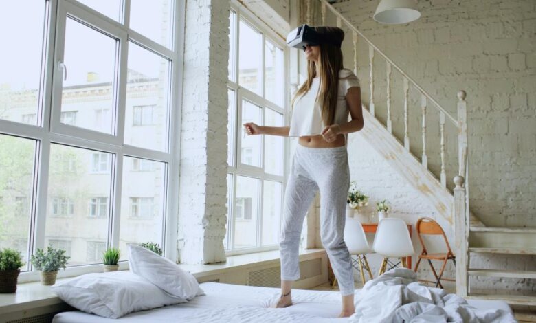 Woman wearing vr headset standing on bed